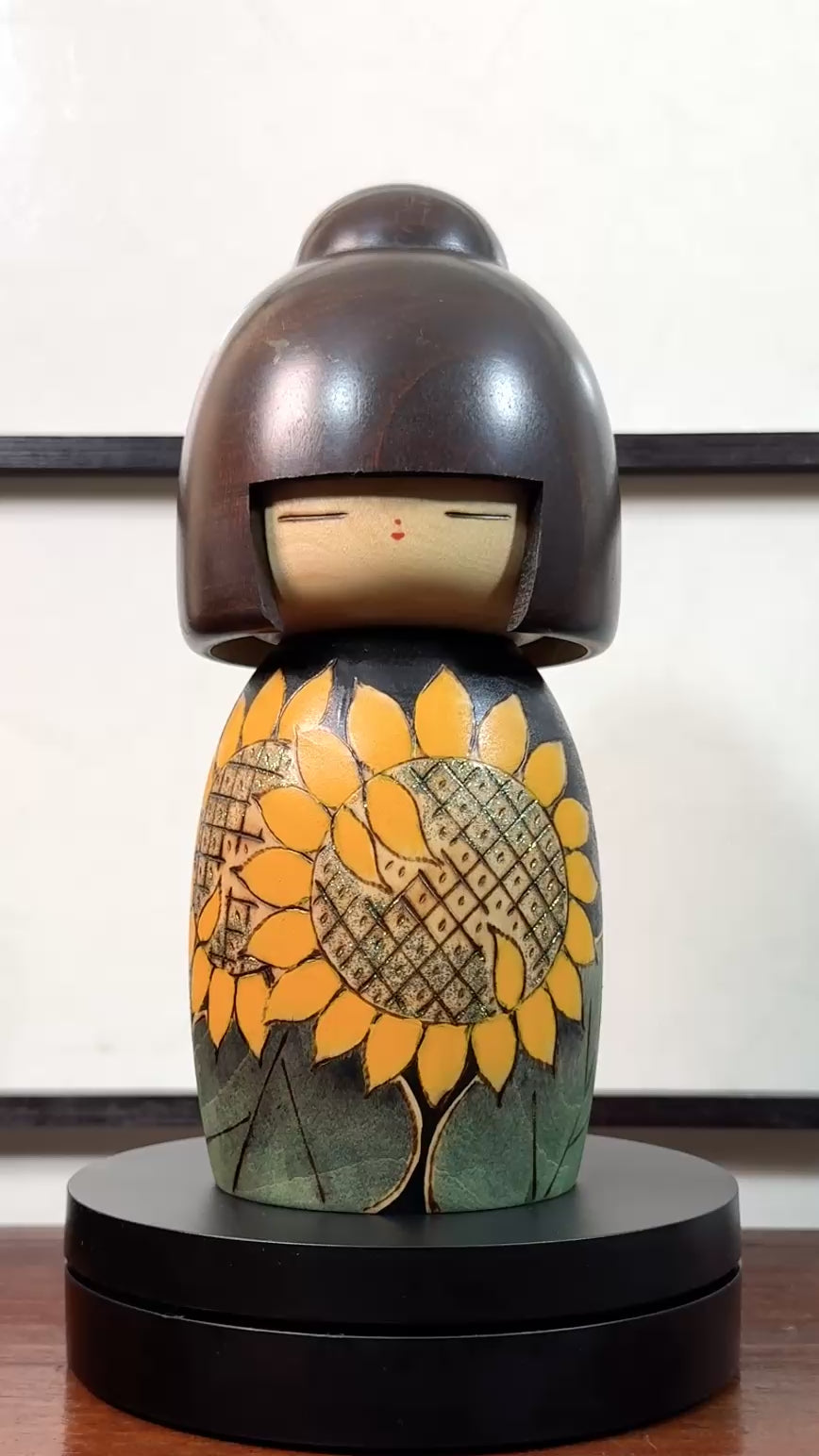Kokeshi vintage japonaise de Yuji Kawase ornée de grands tournesols jaunes gravés et peints sur fond vert et noir, la vidéo à 360 degrés