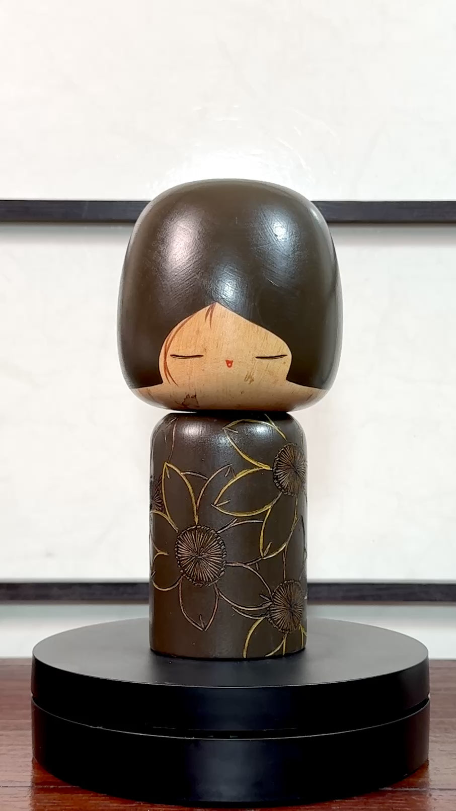 Kokeshi vintage de Yuji Kawase caractérisée par une grande tête brune, un corps étroit et un décor de fleurs gravées, la vidéo à 360 degrés