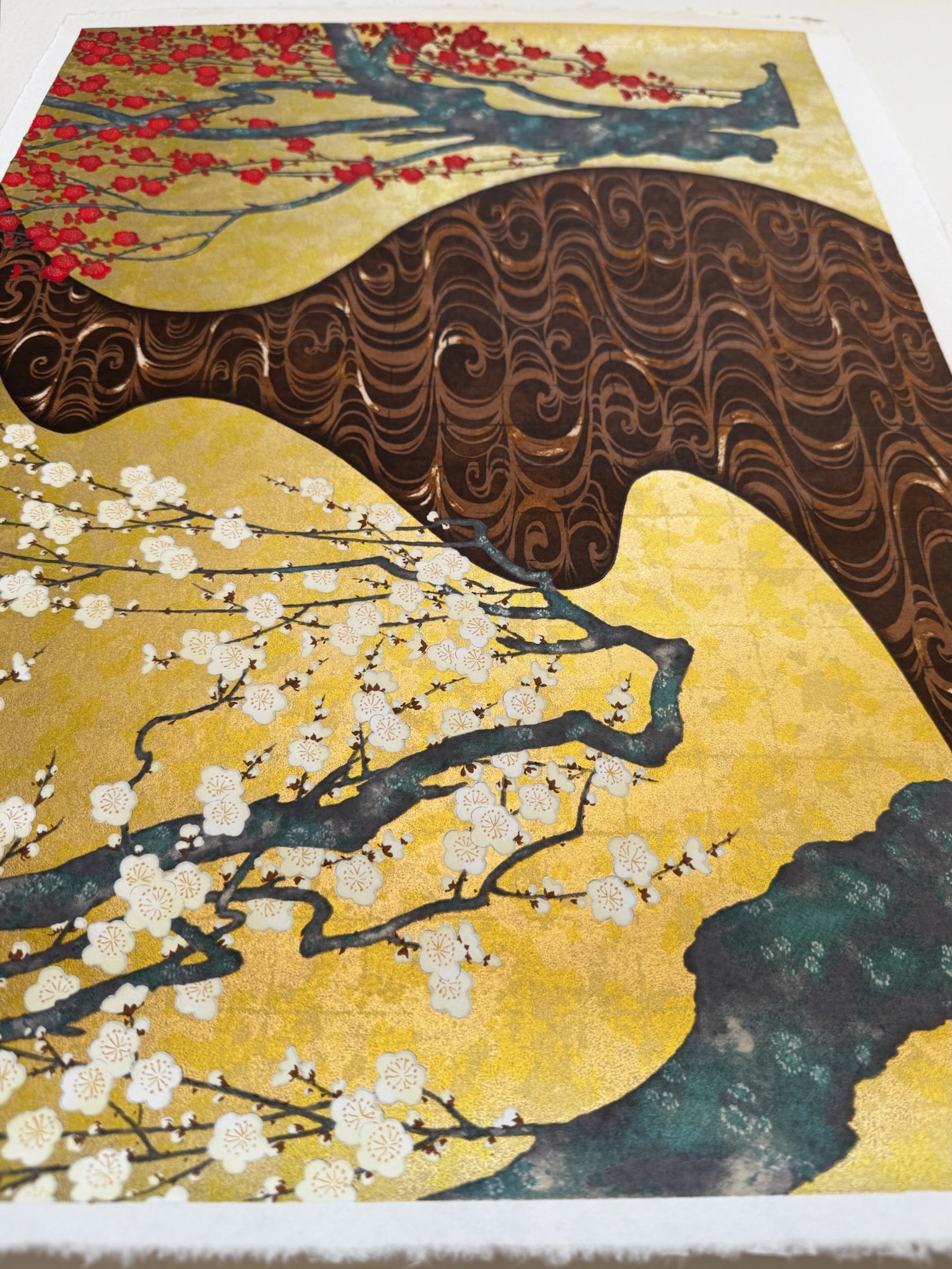 Sérigraphie japonaise d'un paysage de printemps. Deux pruniers , l'un blanc et l'autre rouge, séparés par une rivière marron.  Profil, brillance