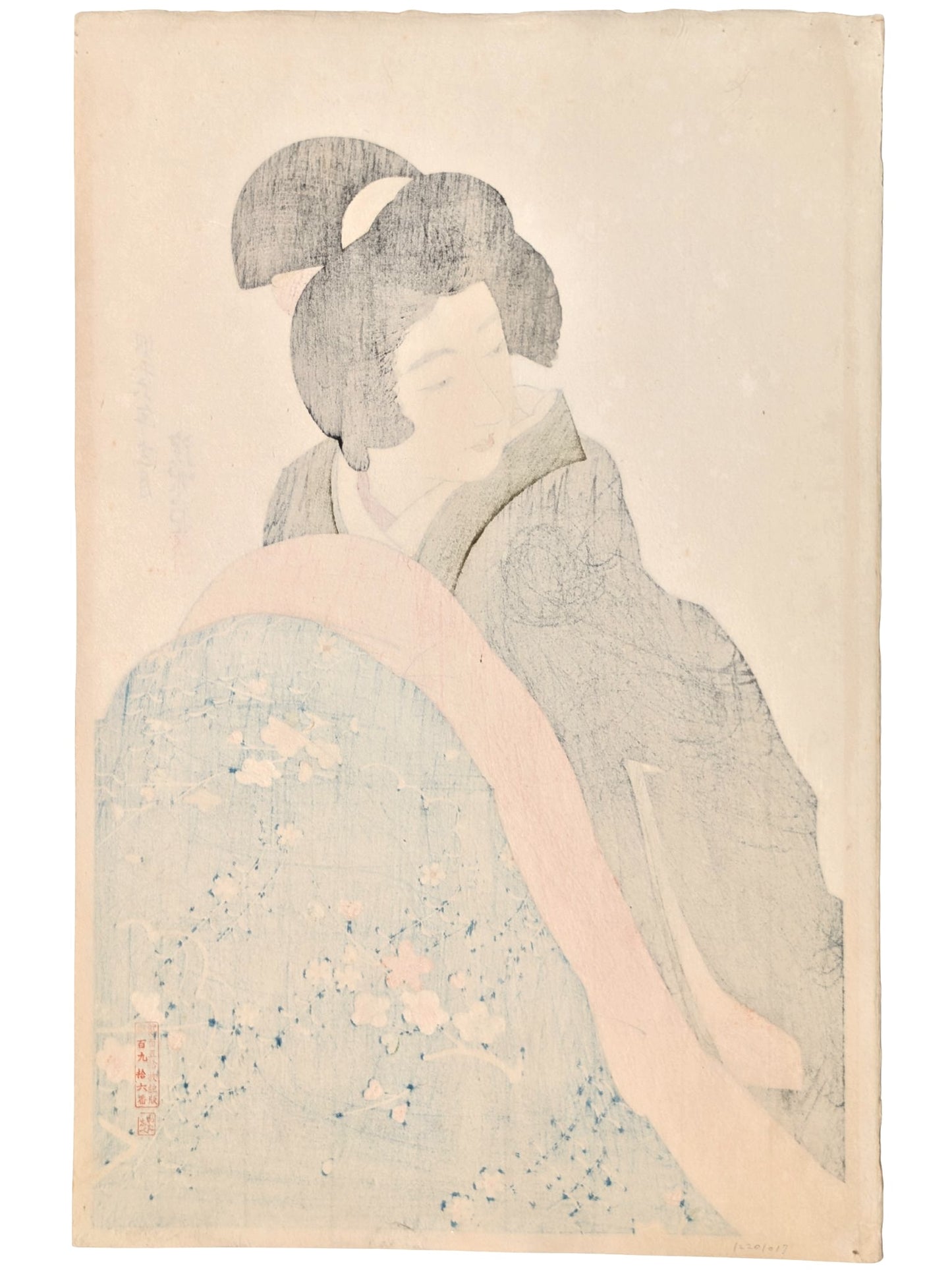 Une femme japonaise en kimono noir se réchauffe sous une couverture florale, assise à un kotatsu, dans une estampe de Itō Shinsui réalisée en 1932, issue d’un rare premier tirage, le verso