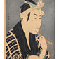 Estampe japonaise de Sharaku Toshusai d'un acteur de Kabuki fumant la pipe. Kimono à carreaux bleu marine. Il semble chercher un objet dans sa manche. Fond micacé argenté typique de cet artiste.