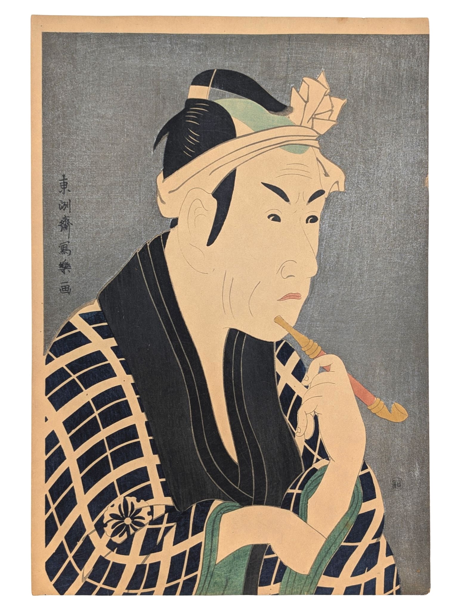 Estampe japonaise de Sharaku Toshusai d'un acteur de Kabuki fumant la pipe. Kimono à carreaux bleu marine. Il semble chercher un objet dans sa manche. Fond micacé argenté typique de cet artiste.