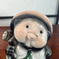 Tirelire tanuki en céramique émaillée noire et crème, style japonais traditionnel, gros plan sur le visage aux joues roses