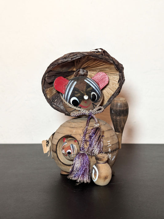 Tanuki en bois avec chapeau, bouteille de saké et bébé tanuki, sculpture japonaise artisanale symbolisant chance et prospérité, vu de face