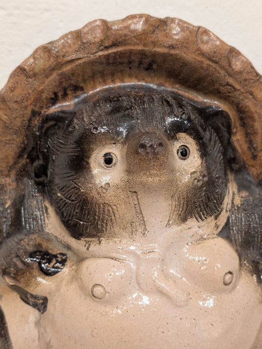 Tanuki en céramique avec chapeau et ventre rond, gros plan sur la tête