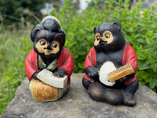 couple de Tanuki en céramique vintage, fille avec livre de compte et garçon avec boulier