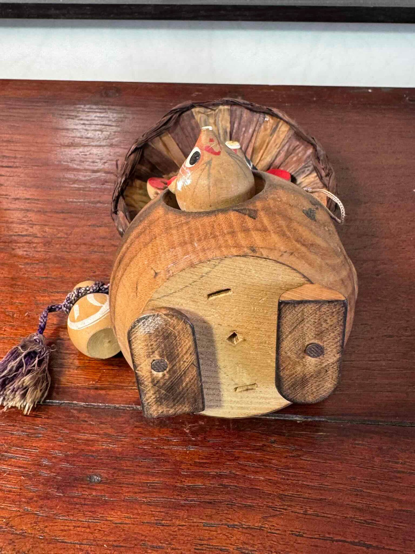 tanuki en bois avec son chapeau, bébé et sa bouteille de saké, vu de dessous