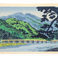 Estampe japonaise de Tokuriki, le pont Togetsukyō aux pieds des montagnes de arashiyama sous la pluie fine. montagne verdoyante et rivière kamo bleue.