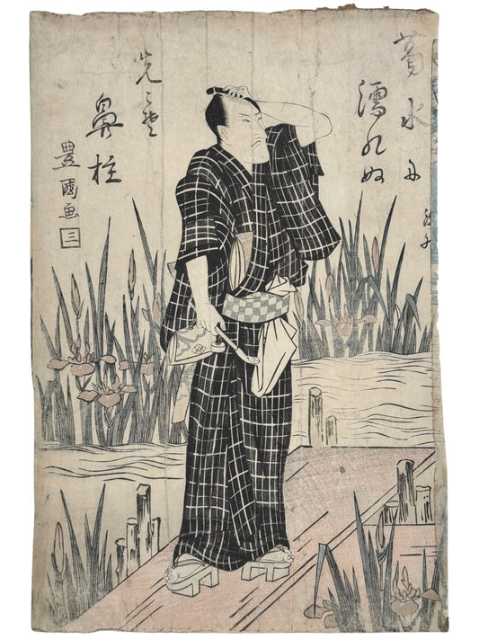 estampe japonaise de Toyokuni 1 un homme en kimono d'été à carreaux main sur la tête, ponton roseaux et iris 