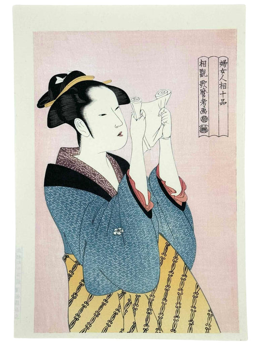 estampe japonaise de Utamaro, courtisane en kimono bleu et june lisant une lettre, fond rose micacé