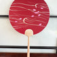 éventail japonais uchiwa rouge, des pétales de cerisier flottent sur l'eau, recto