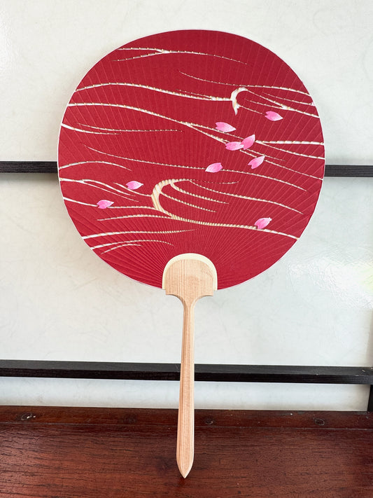 éventail japonais uchiwa rouge, des pétales de cerisier flottent sur l'eau, recto