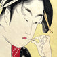 estampe japonaise geisha un sein nu, cure dent dans la bouche, bros plan sur le visage de la femme