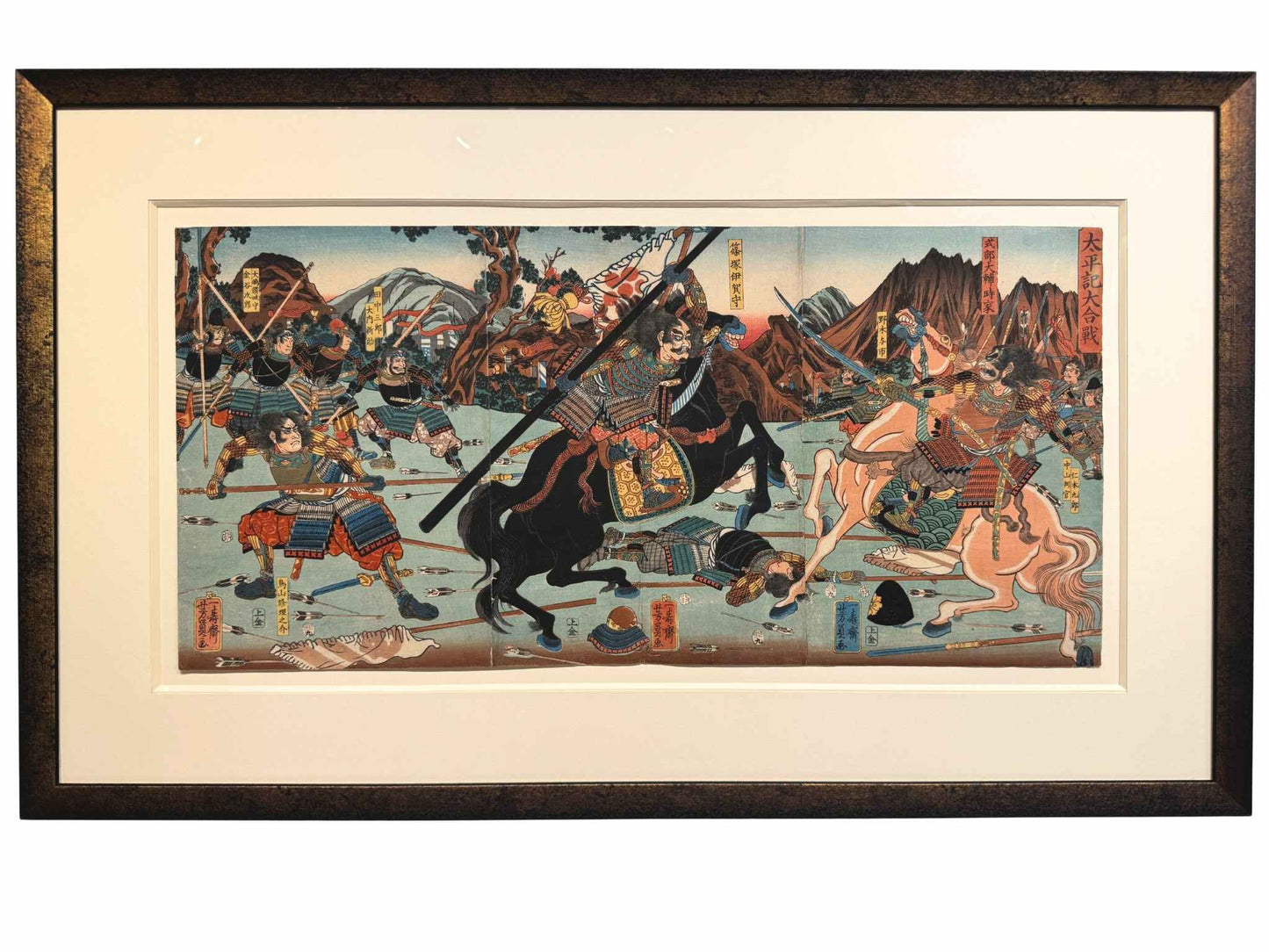 Estampe Japonaise triptyque encadrée de Yoshikazu représentant une bataille entre samourai en armure à cheval, avec cadre or patiné noir