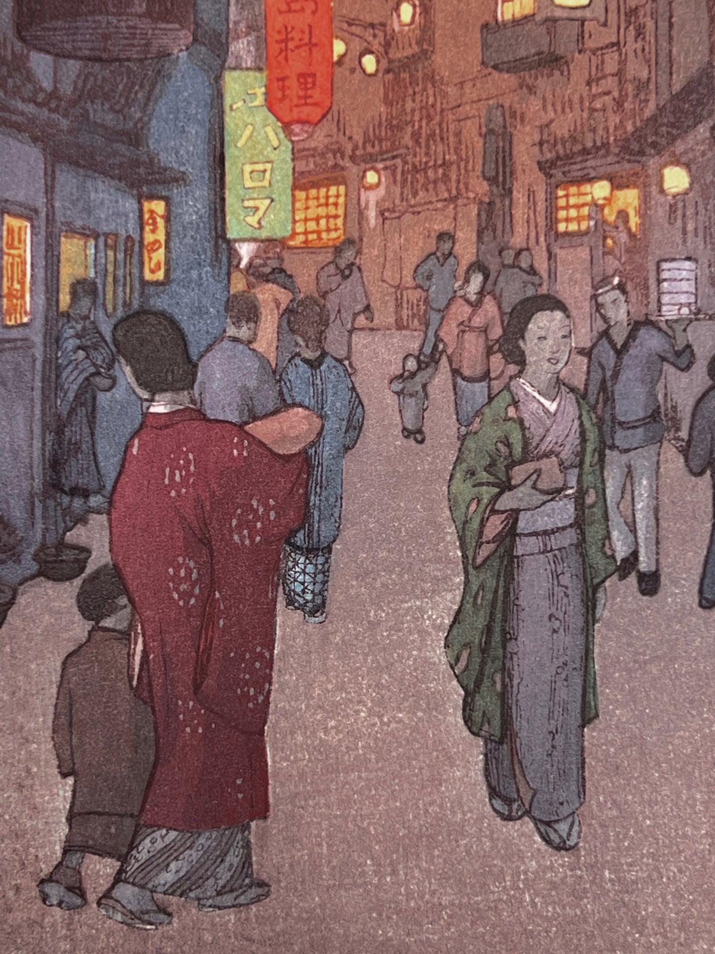 Passants, femmes et enfants en kimono dans les rues illuminées de Shinjuku à Tokyo.