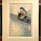 Estampe japonaise de yoshitoshi femme aux longs cheveux, en kimono noir à motif et obi rouge,  tenant un luth sur une barque, encadrée avec un cadre noir à angle rouge chine et bagues or