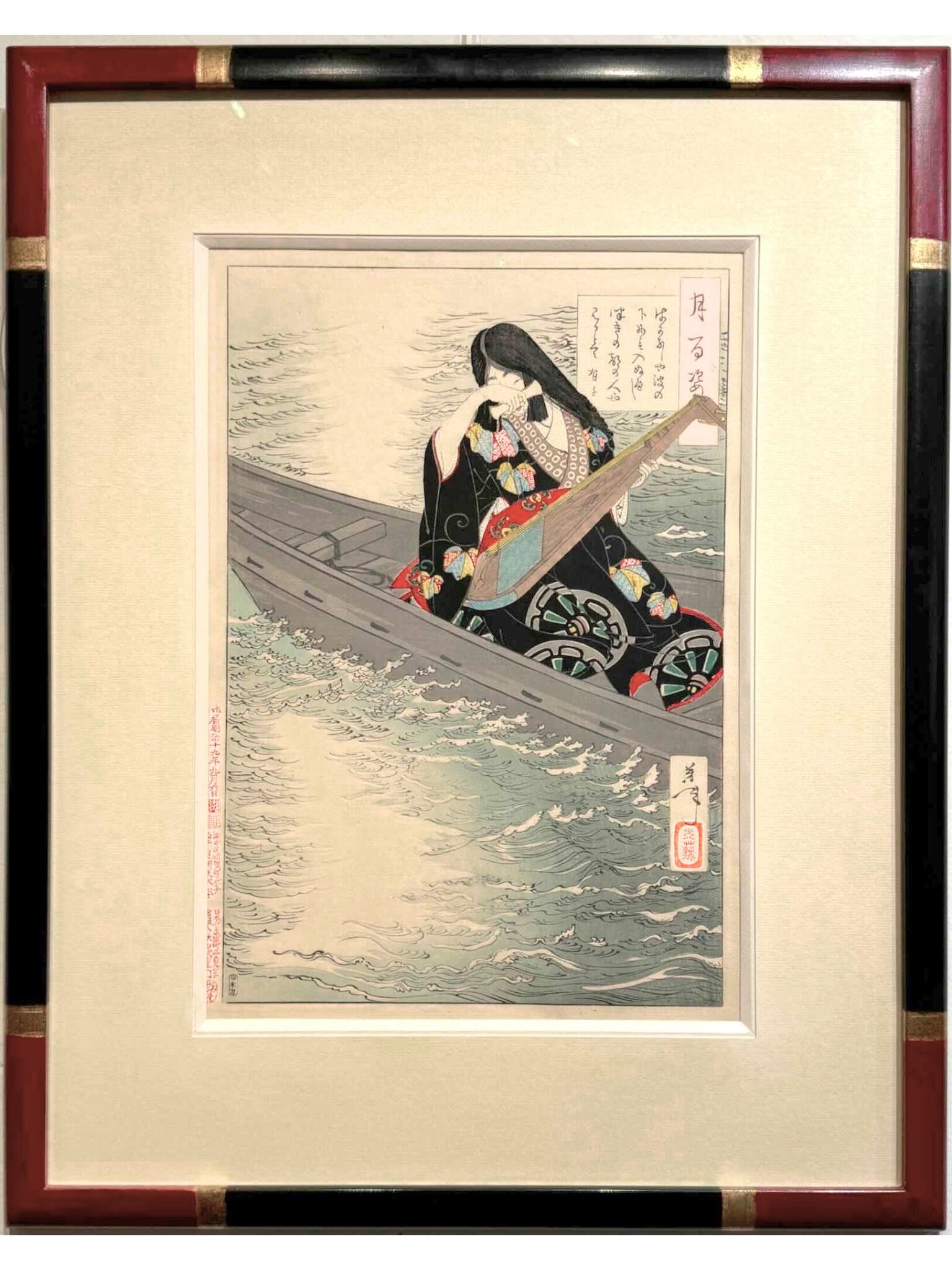 Estampe japonaise de yoshitoshi femme aux longs cheveux, en kimono noir à motif et obi rouge,  tenant un luth sur une barque, encadrée avec un cadre noir à angle rouge chine et bagues or