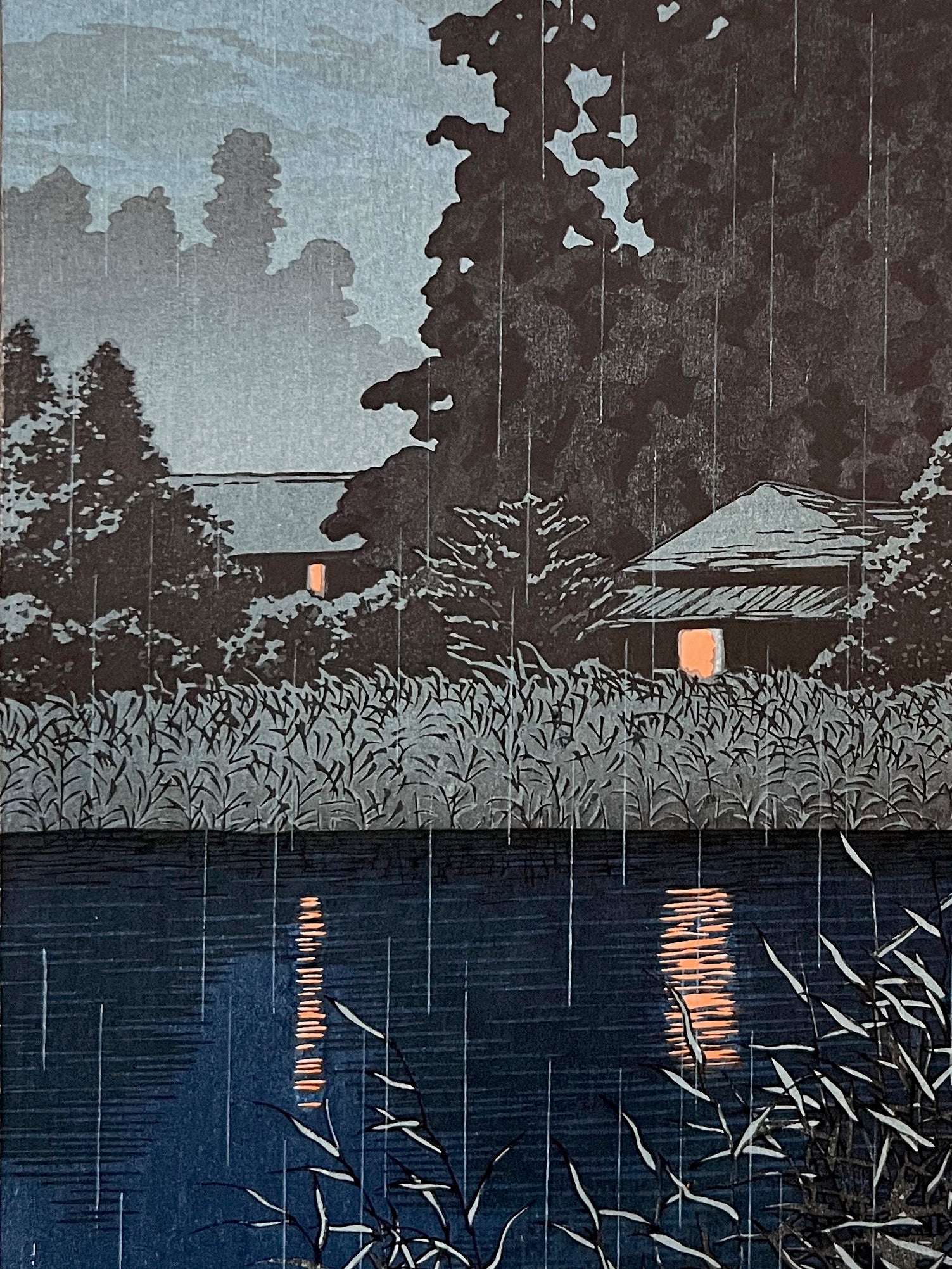 estampe japonaise de Hasui kawase la pluie sur le lac de Omiya la nuit, les chaumières éclairées