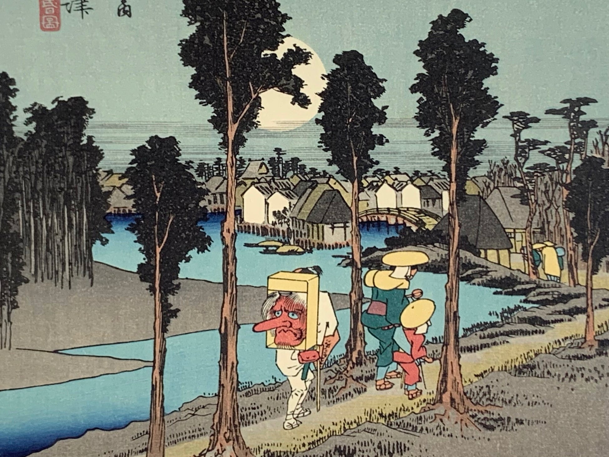 estampe japonaise de Hiroshige, des voyageurs sur la route du Tokaido arrivent au village de Nemazu, sous une nuit de pleine lune. Un voyageur porte un masque de Tengu sur son dos