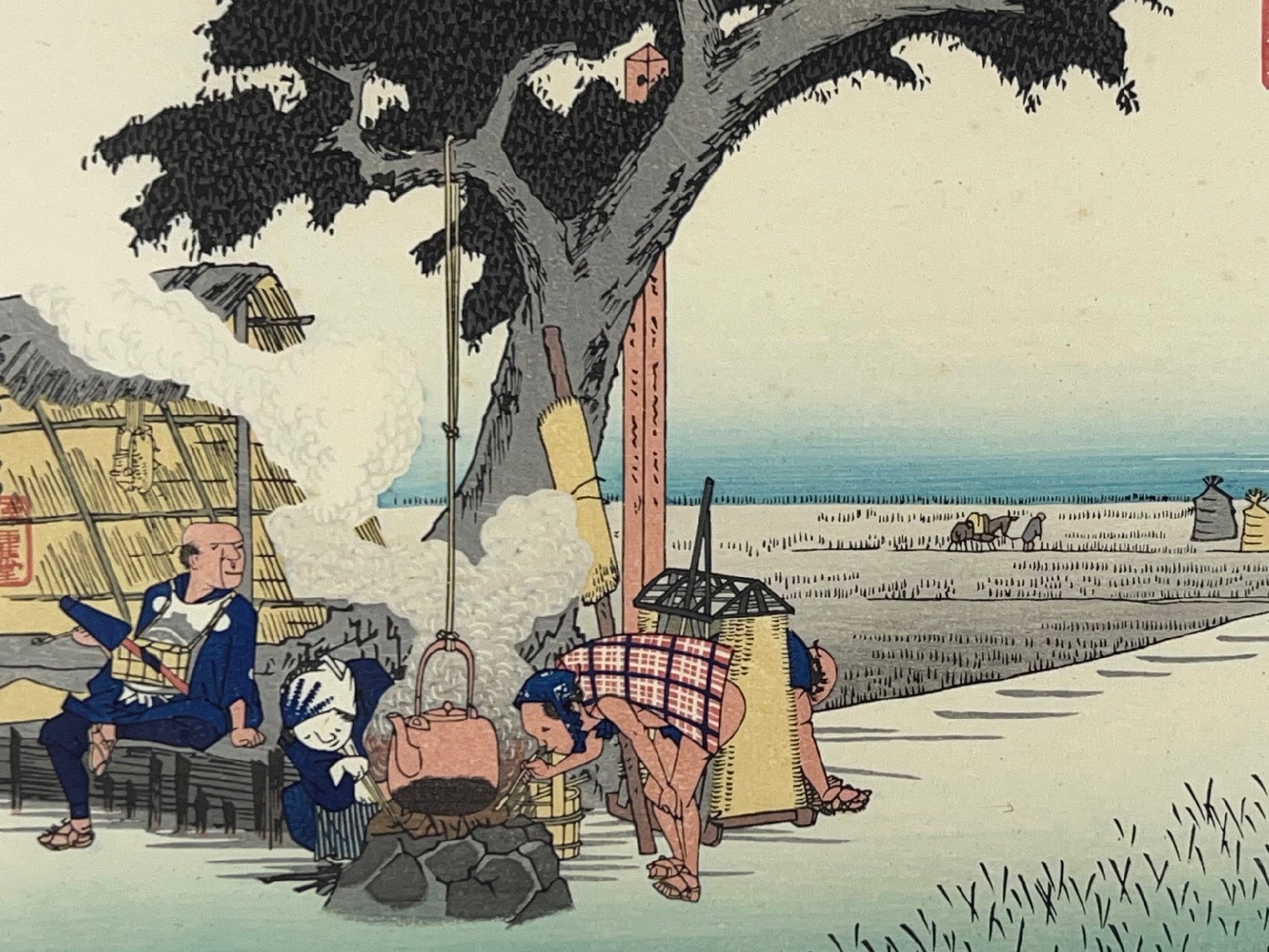 estampe japonaise de paysage d'Hiroshige, un homme et une femme attise le feu sous une bouilloire accrochée à un arbre au milieu des champs de riz