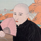estampe japonaise homme en kimono noir assis , tenant un éventail, et regardant le spectateur