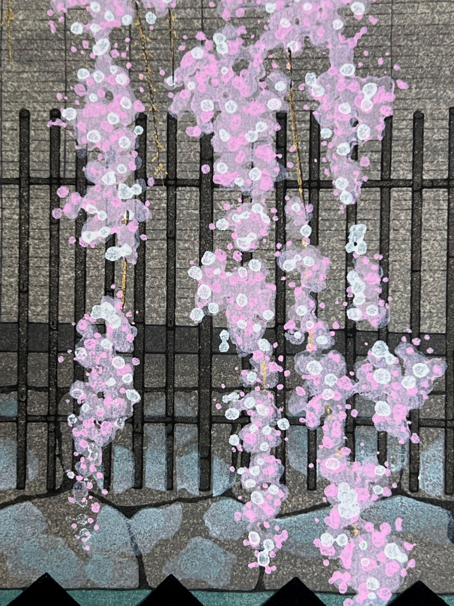 estampe japonaise cerisier en fleur descendant sur une barrière rouge et noire, gros plan sur les fleurs de cerisier