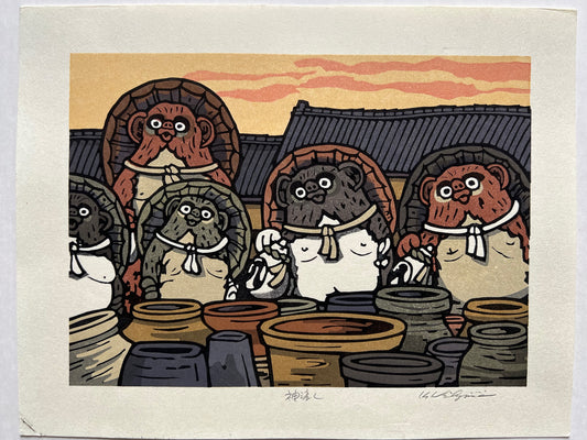 estampe japonaise groupe de tanuki devant des jarres en terre, toit des maisons et ciel jaune orange en arrière plan