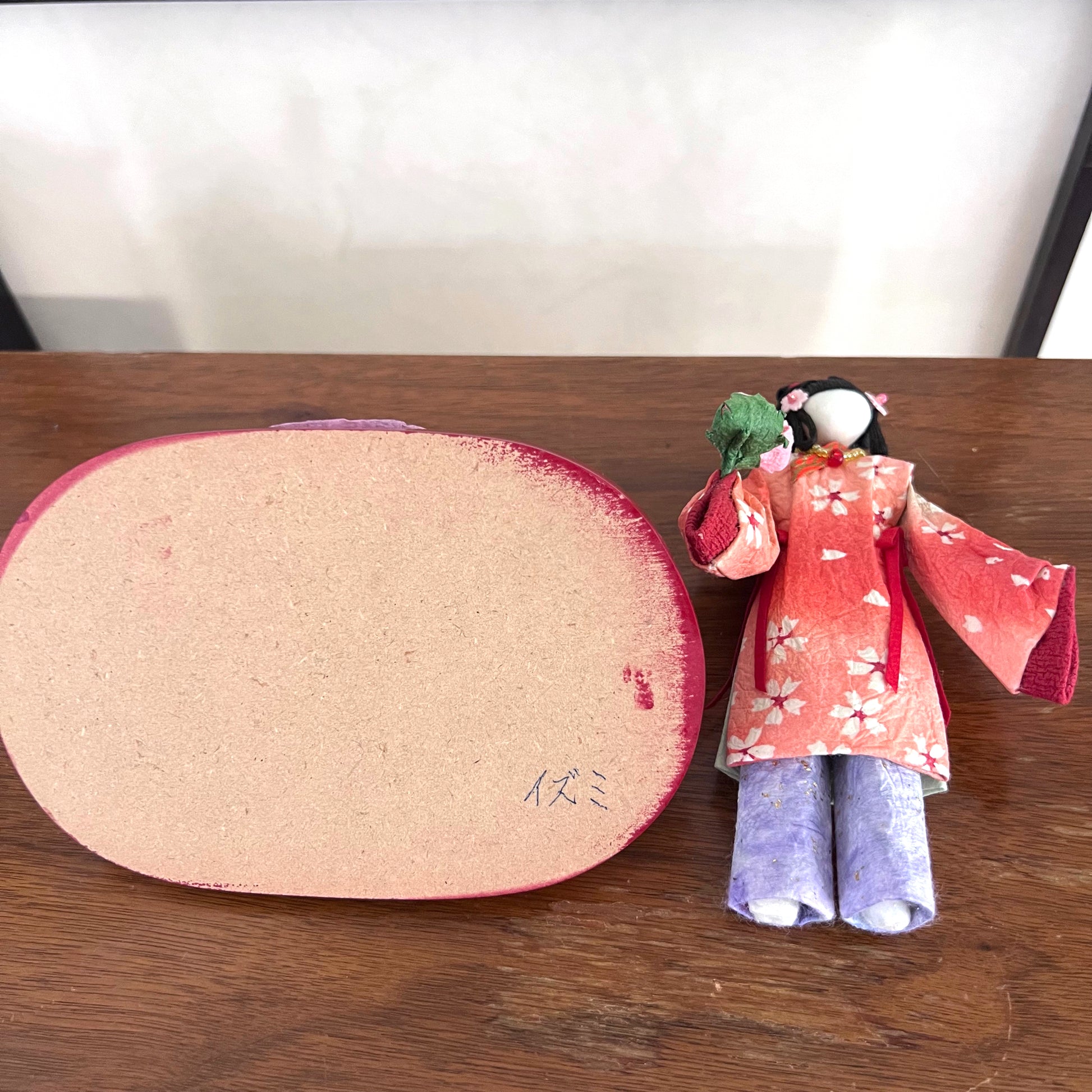 poupée japonaise en papier Yuzen Washi, ( Washi Doll)au kimono fleurs de cerisier tenant une pivoine rose dans la main, vue de dessous