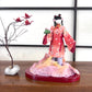 poupée japonaise en papier Yuzen Washi, ( Washi Doll)au kimono  fleurs de cerisier tenant une pivoine rose dans la main