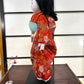 poupée japonaise Ichimatsu fille, le devant du kimono en soie rouge, vu du côté  gauche