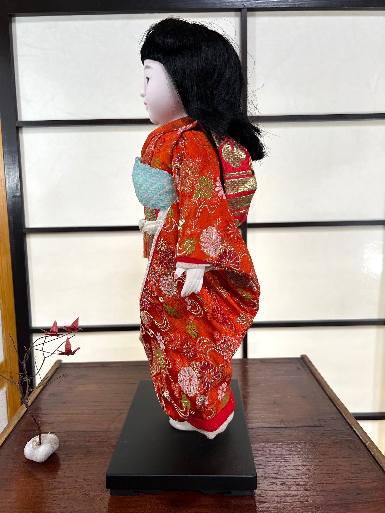 poupée japonaise Ichimatsu fille, le devant du kimono en soie rouge, vu du côté  gauche