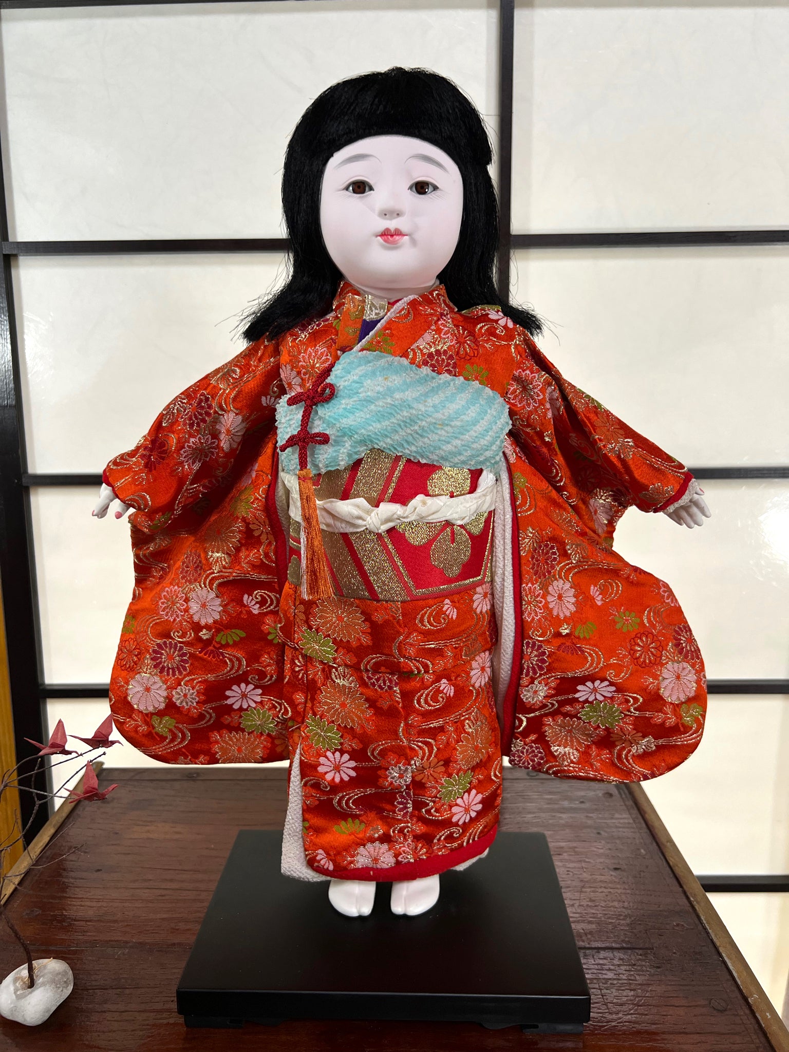 poupée japonaise Ichimatsu fille, le devant du kimono en soie rouge, vu de face manches dépliées