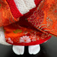 poupée japonaise Ichimatsu fille, le devant du kimono en soie rouge,  vu des pieds chaussés de tabi blanches