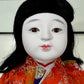 poupée japonaise Ichimatsu fille, le devant du kimono en soie rouge,  détail du visage