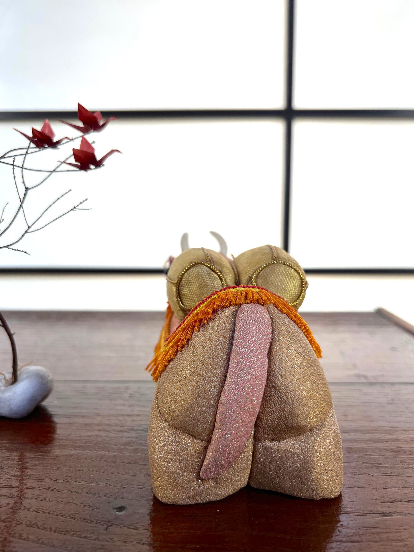 Buffle en poupée japonaise  Kimekomi, vu de dos avec sa queue rose