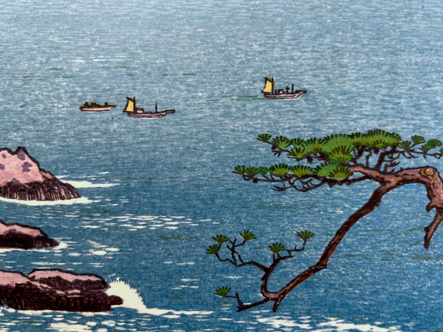estampe japonaise paysage maritime mer bleur, rocher et pin, bateaux sur la mer, branche d'un pin en premier plan