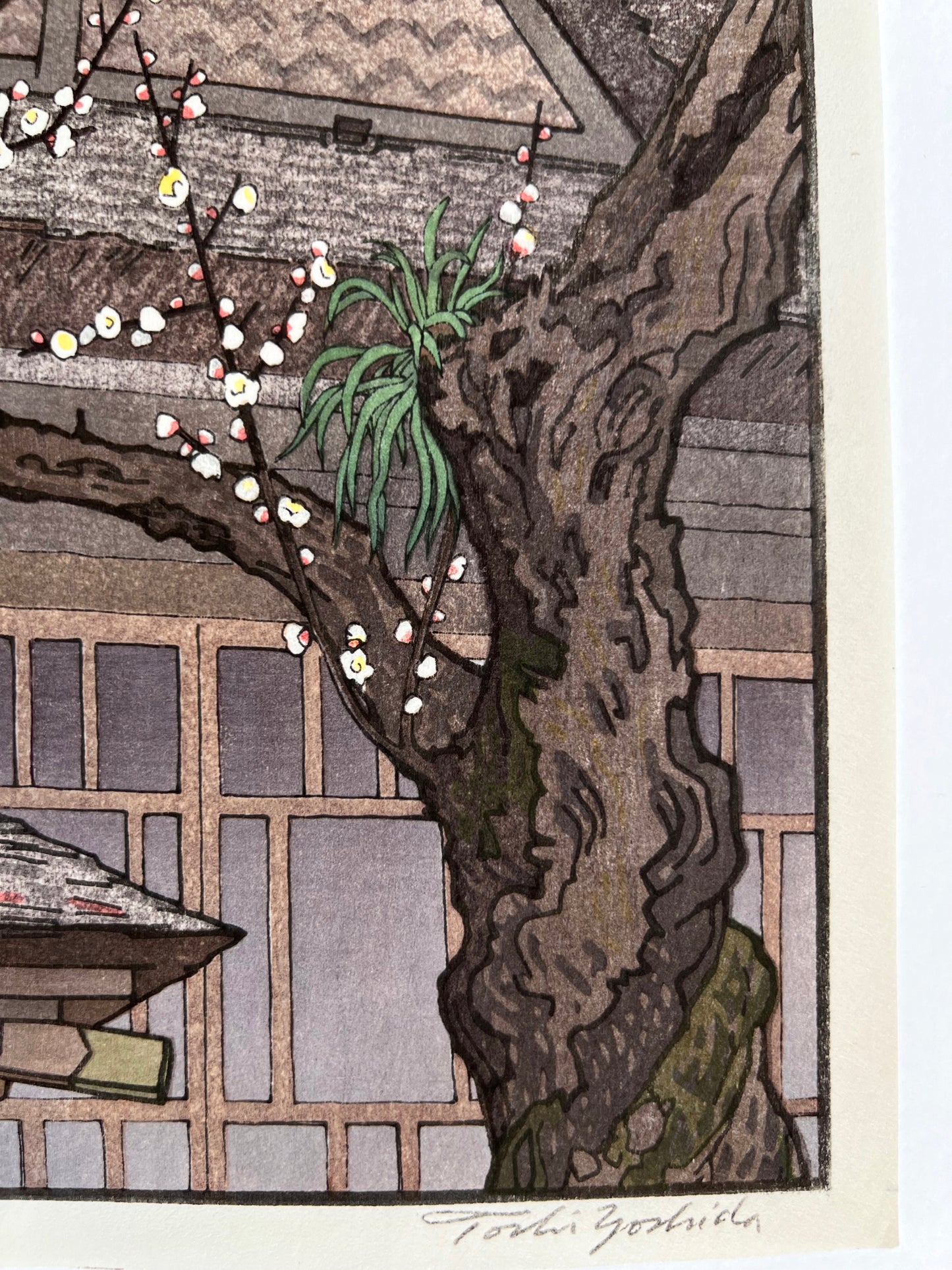 estampe japonaise prunier en fleurs au printemps devant un temple, gros plan sur le trons et la signature de l'artiste